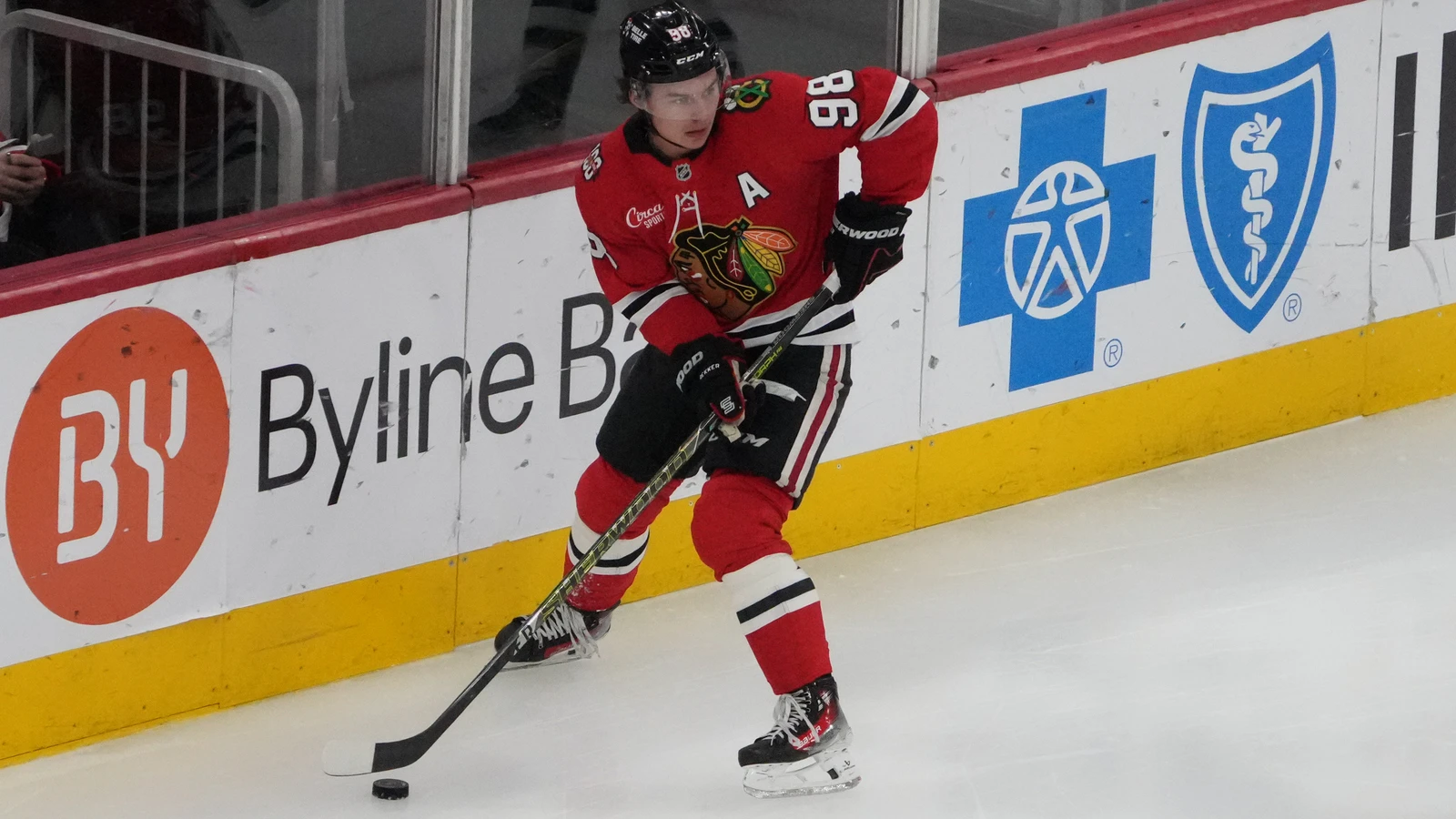 File photo: Chicago Blackhawks centre Connor Bedard skates with the puck by the boards during an April 15, 2026 game against the San Jose Sharks in Chicago.