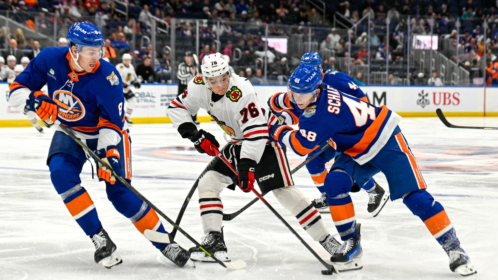 File photo: Chicago Blackhawks forward Nick Lardis controls the puck between New York Islanders defenders at UBS Arena.