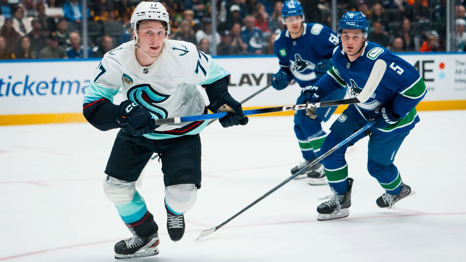 File photo: Vancouver Canucks defenceman Guillaume Brisebois, No. 55, tracks a loose puck alongside Seattle Kraken forward Berkly Catton at Rogers Arena on September 26, 2025.
