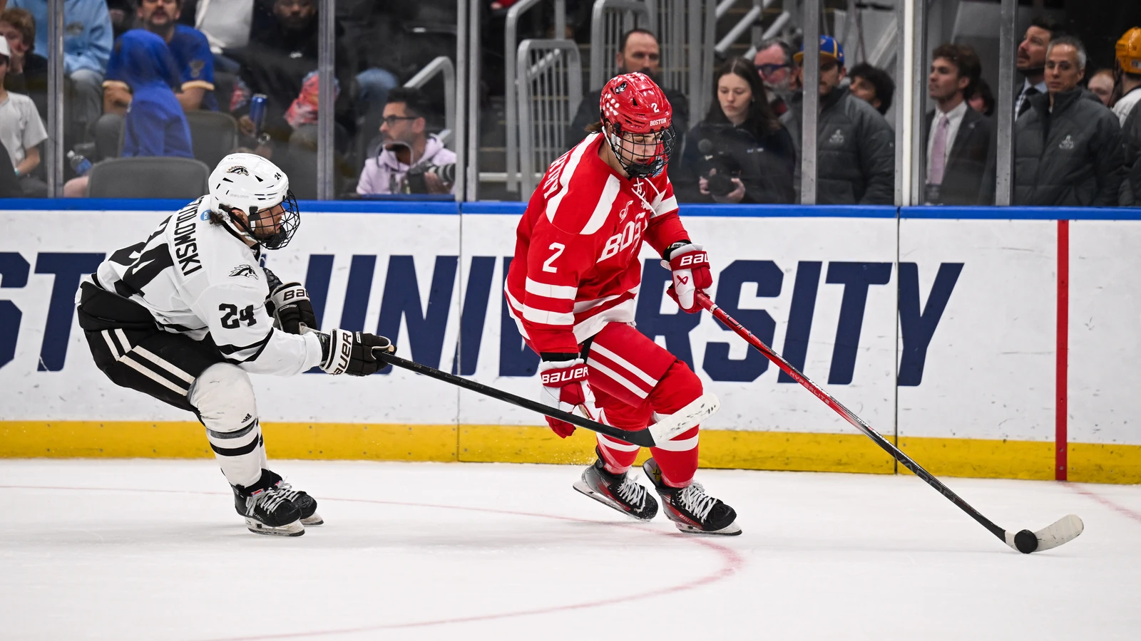 Boston University defenseman Gavin McCarthy controls the puck under pressure from Western Michigan's Garrett Szydlowski in the Frozen Four final on April 12, 2025. File photo.