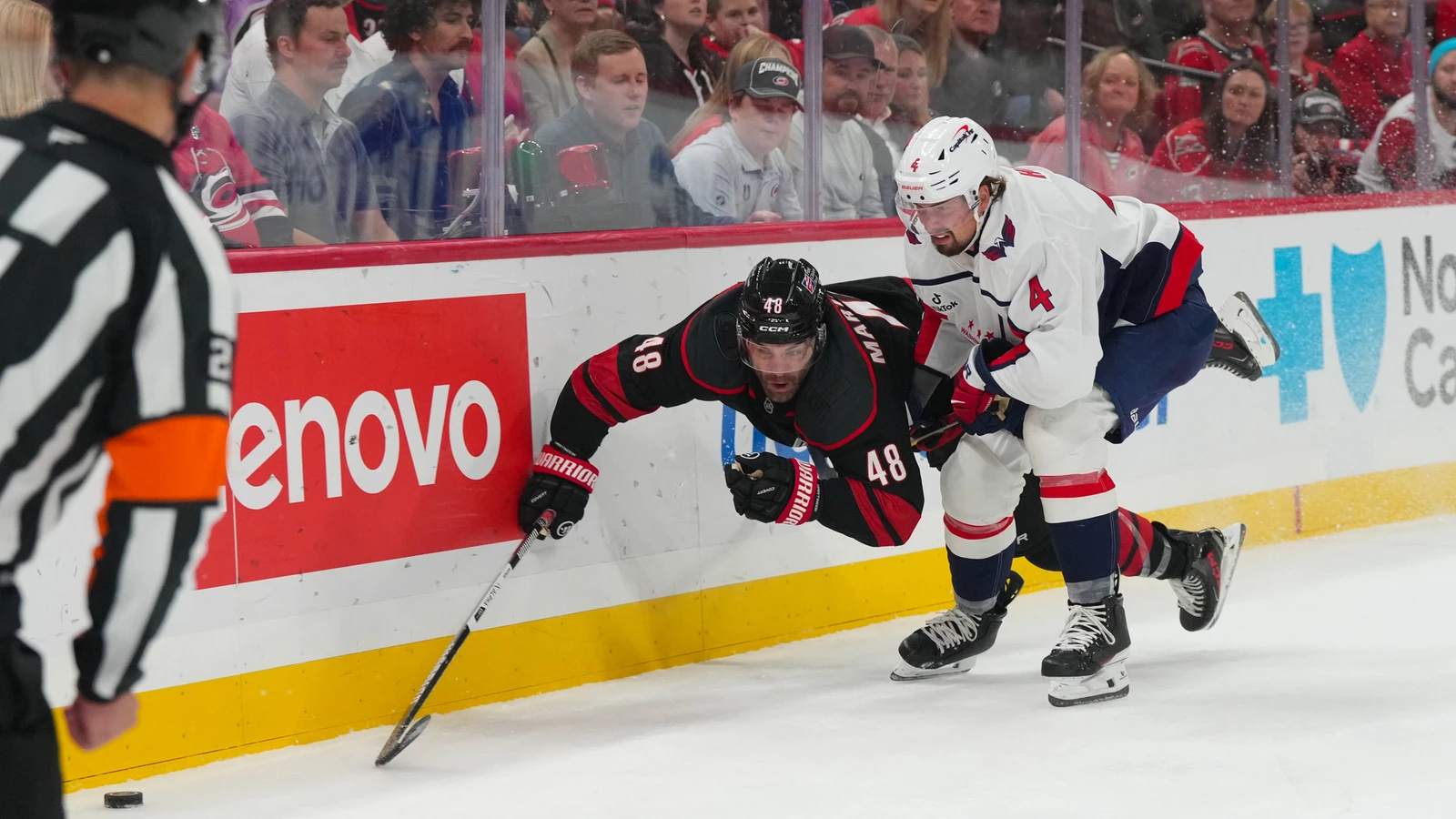 File photo: Washington Capitals defenceman Justin Holl checks Carolina Hurricanes forward Jordan Martinook along the boards.