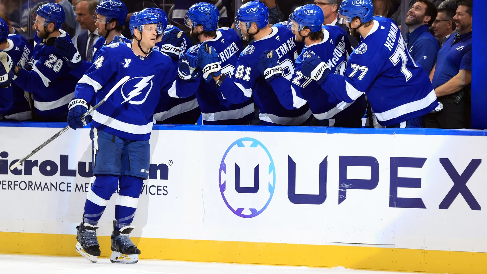John Carlson skates past the Tampa Bay Lightning bench as teammates congratulate him after his second-period goal against the Minnesota Wild.