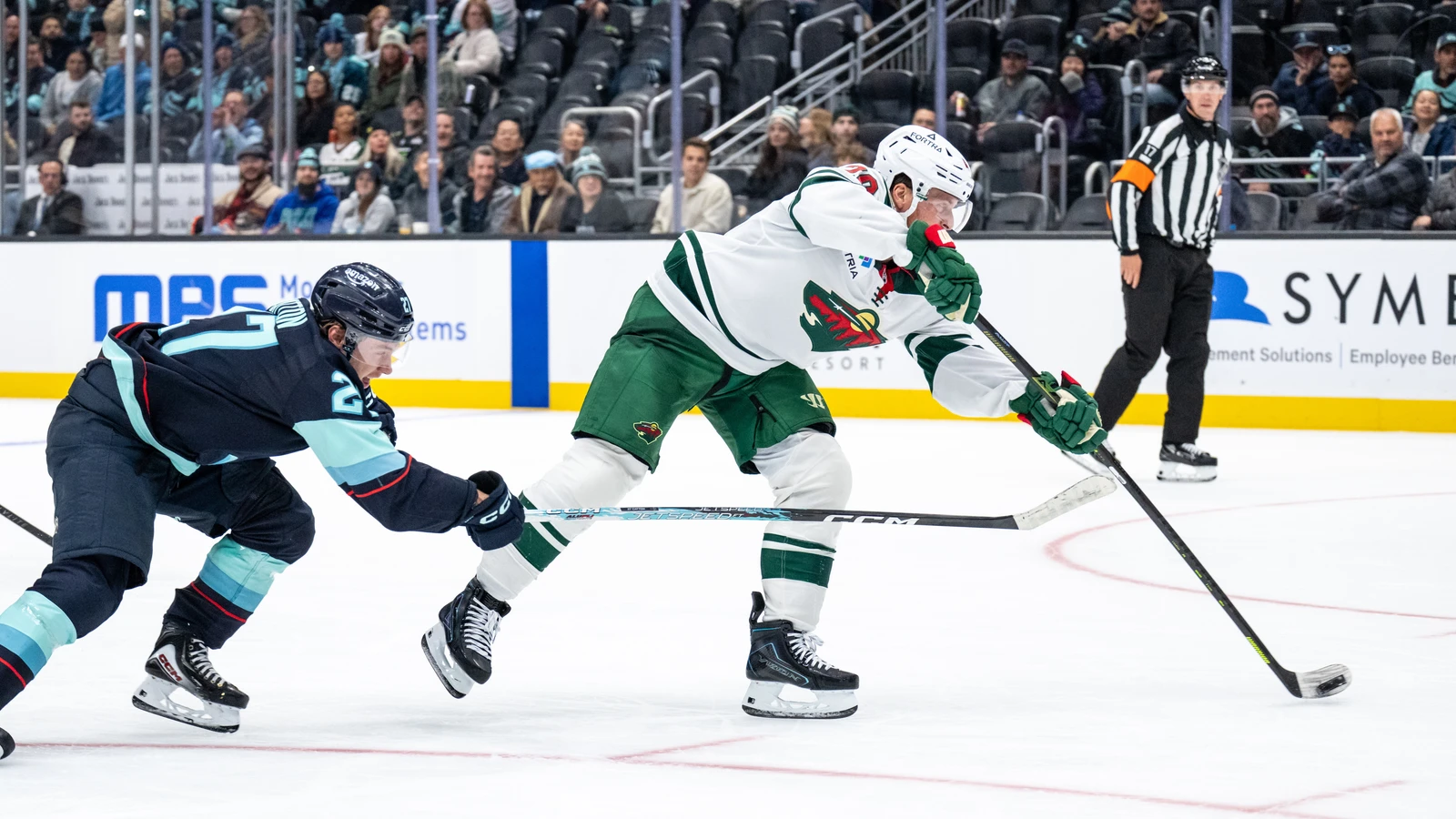 Minnesota Wild forward Blake Coleman shoots the puck with Seattle Kraken forward Berkly Catton pursuing at Climate Pledge Arena.