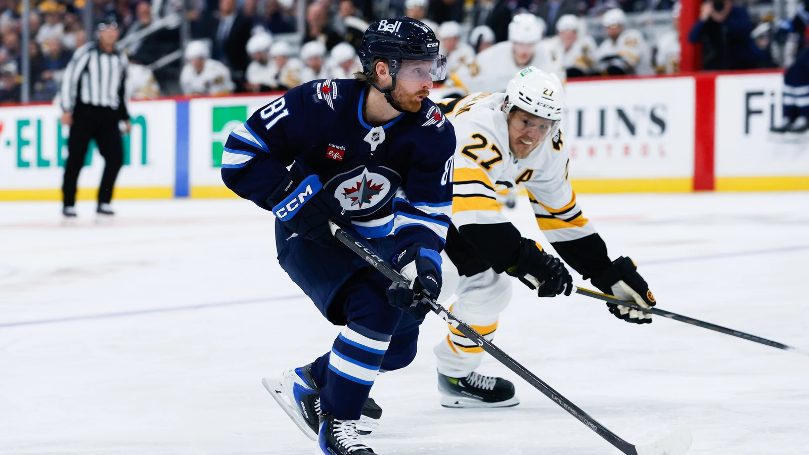 Kyle Connor skates ahead of Hampus Lindholm during Winnipeg’s season opener against Boston.