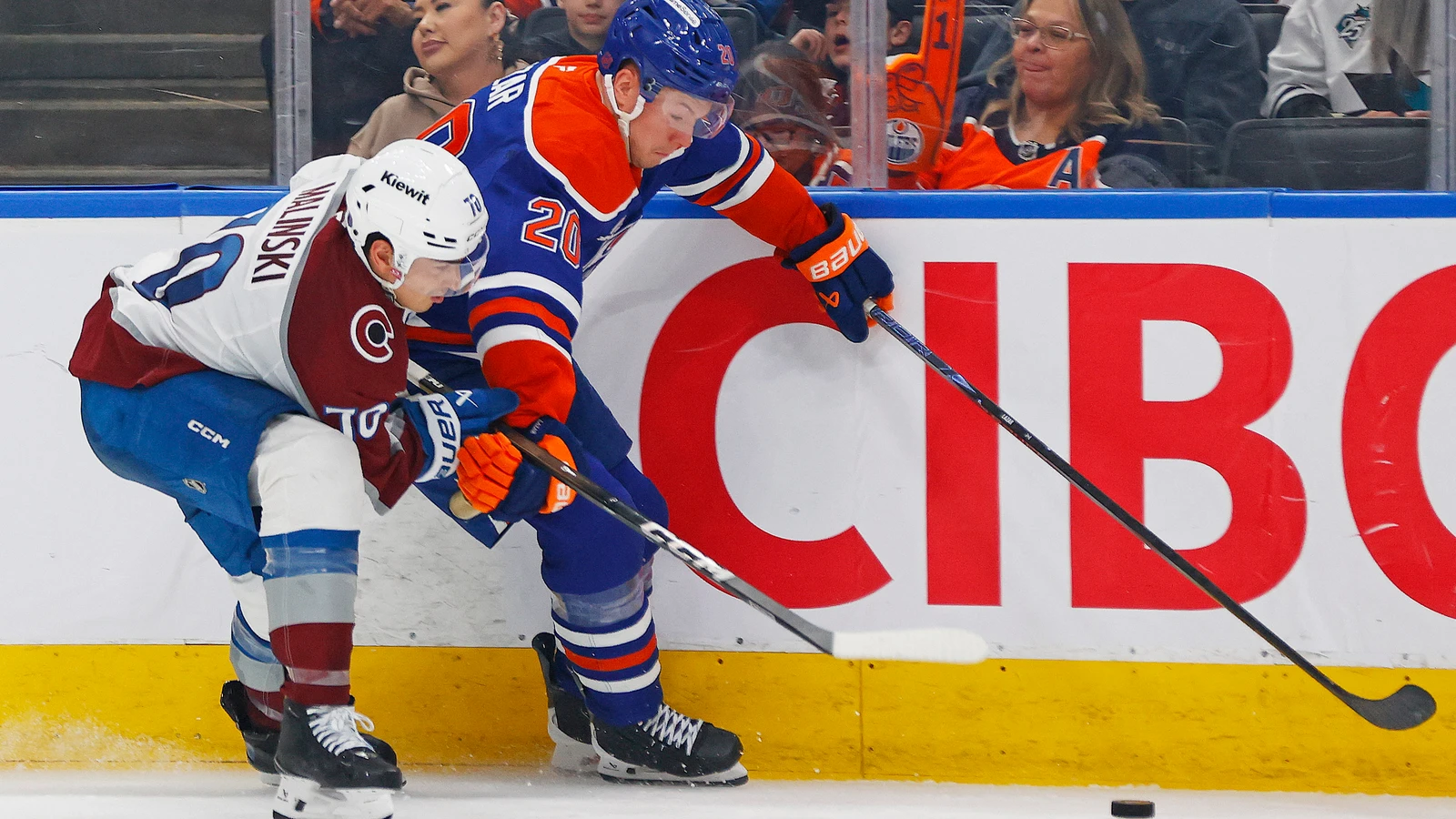 Curtis Lazar battles Sam Malinski for the puck during an April 2026 Oilers game. File photo.