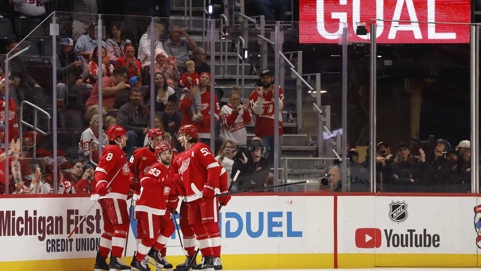 File photo: Red Wings forward Alex DeBrincat is congratulated by teammates after scoring against the Devils at Little Caesars Arena.