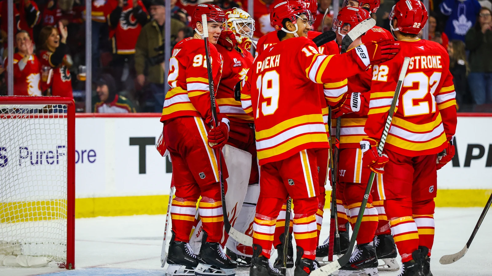 File photo: Calgary Flames players gather around their goaltender after a home win at Scotiabank Saddledome.