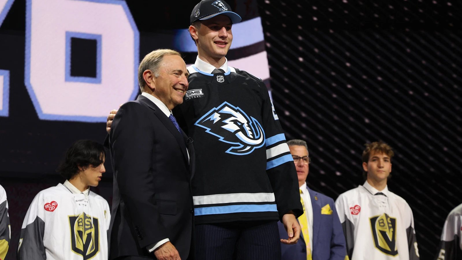 Utah Mammoth first-round pick Ethan Belchetz stands beside NHL commissioner Gary Bettman after being selected at the NHL Draft on June 26, 2026. File photo.