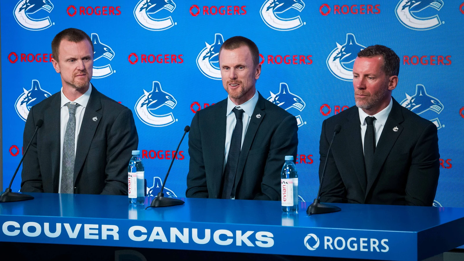 Henrik Sedin, left, listens with Daniel Sedin and Ryan Johnson at a Vancouver Canucks management press conference on May 14, 2026. File photo.