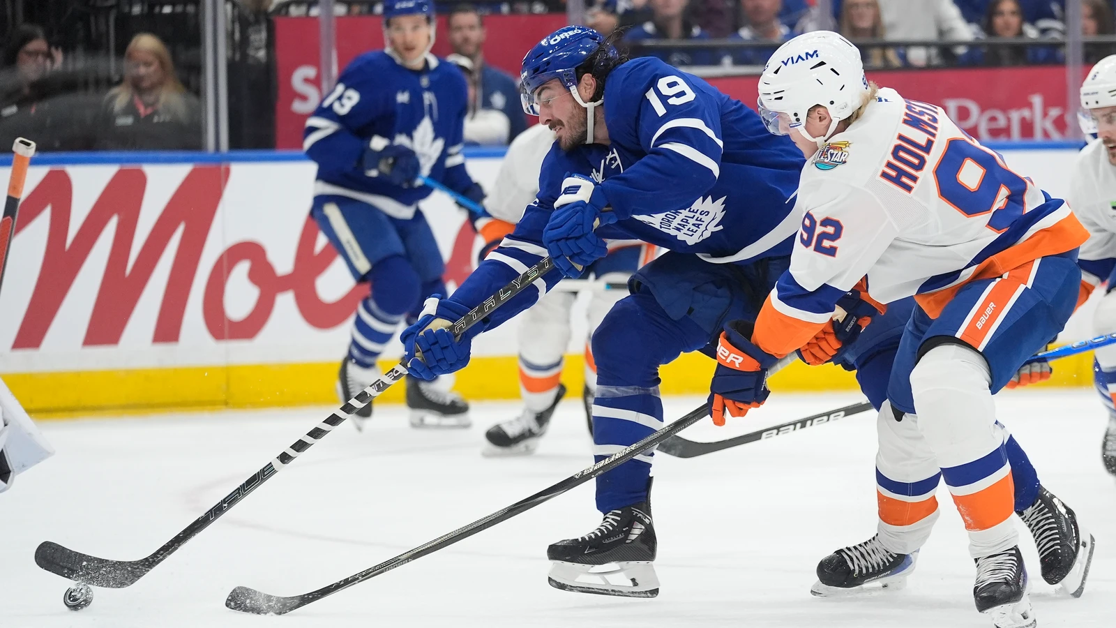 New York Islanders forward Simon Holmstrom defends against Toronto Maple Leafs forward Zack MacEwen.