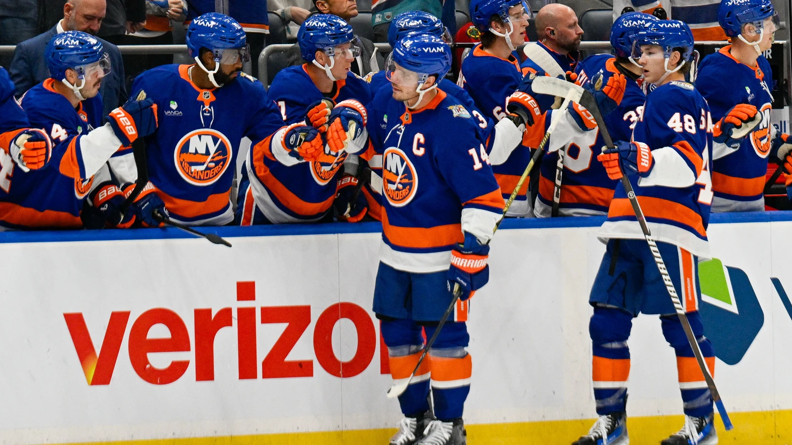Bo Horvat celebrates a goal beside the Islanders bench at UBS Arena.