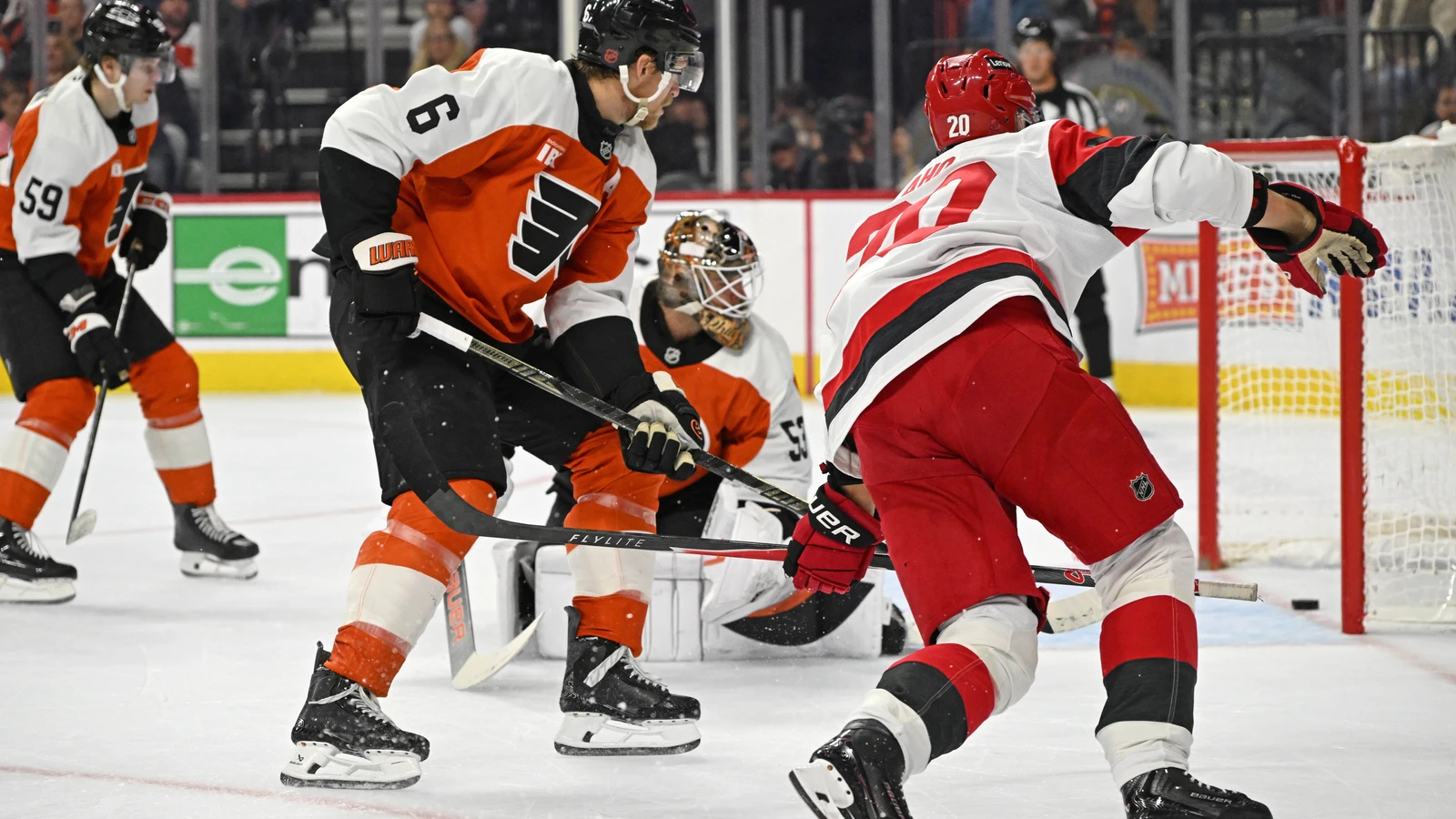 Carolina Hurricanes centre Sebastian Aho shoots past Philadelphia Flyers defenceman Travis Sanheim and goaltender Joseph Woll at Xfinity Mobile Arena.