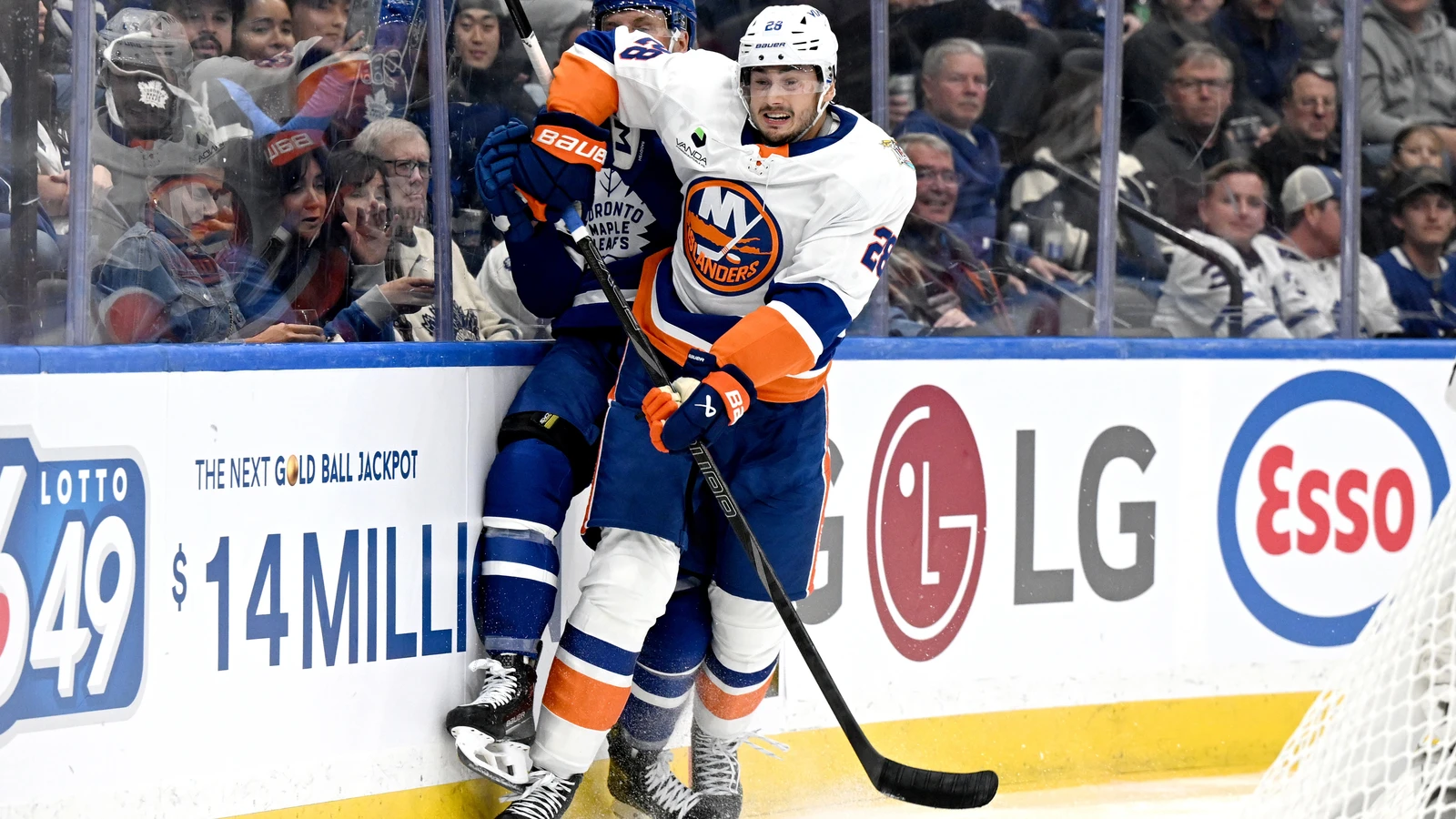 File photo: New York Islanders defenceman Alexander Romanov checks Toronto Maple Leafs defenceman Darren Raddysh against the boards.