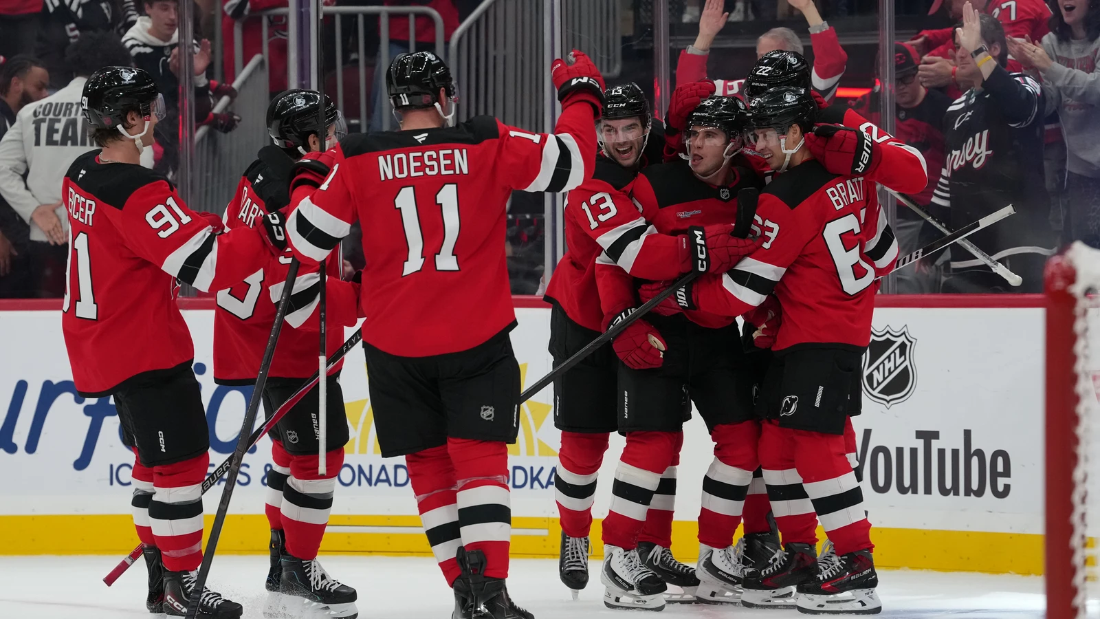 Jack Hughes celebrates with New Jersey Devils teammates after his overtime winner against Philadelphia at Prudential Center.