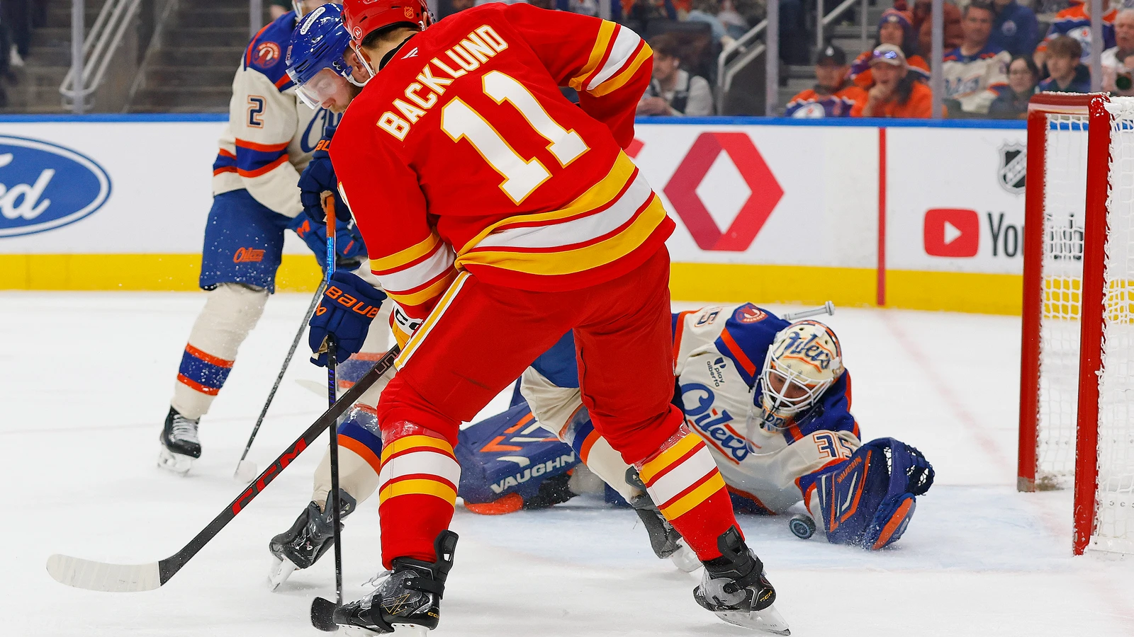Edmonton Oilers goaltender Tristan Jarry makes a save as Calgary Flames forward Mikael Backlund screens him at Rogers Place.