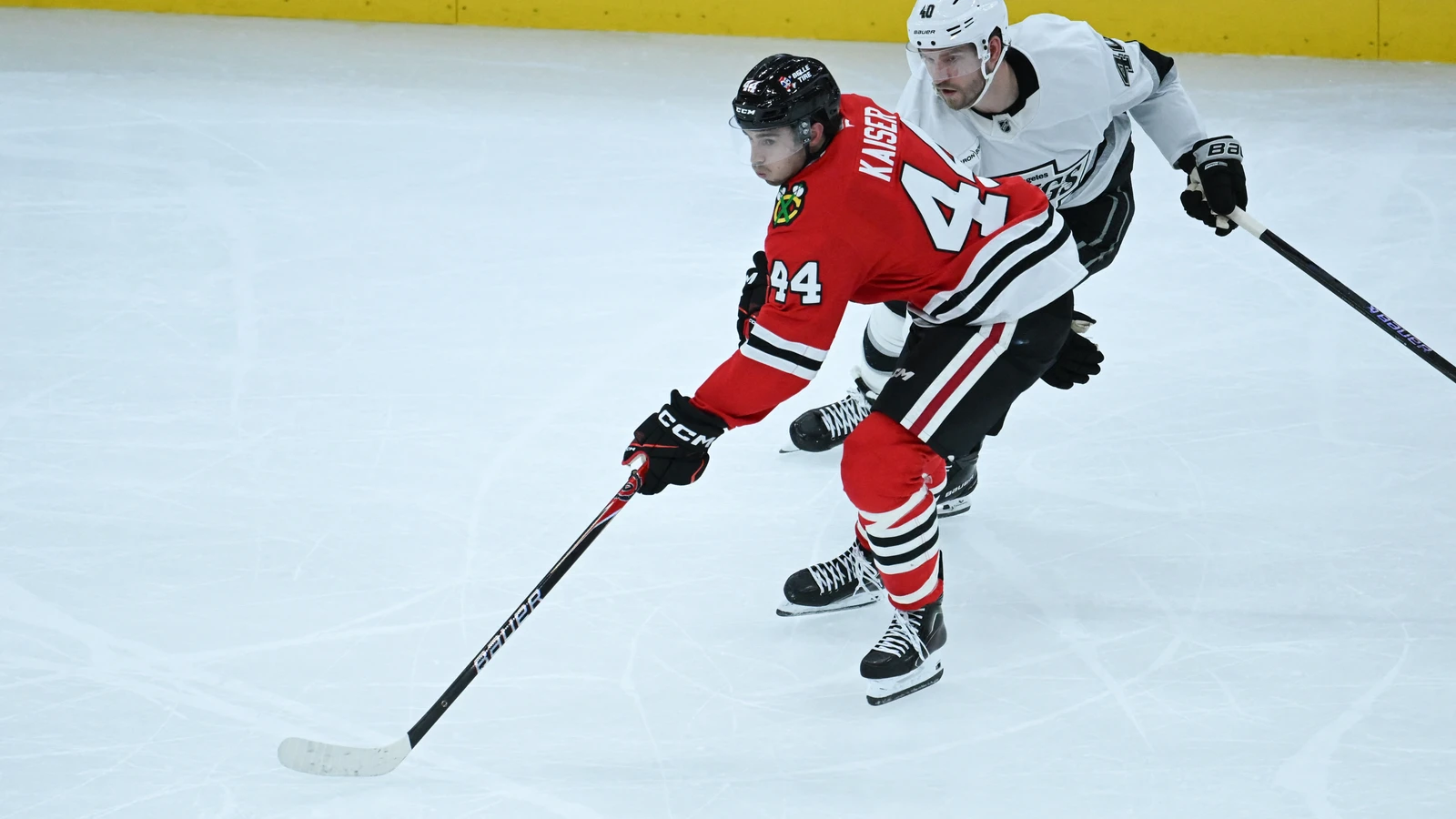 Chicago Blackhawks defenceman Wyatt Kaiser moves the puck while Los Angeles Kings forward Joel Armia pursues him at United Center.