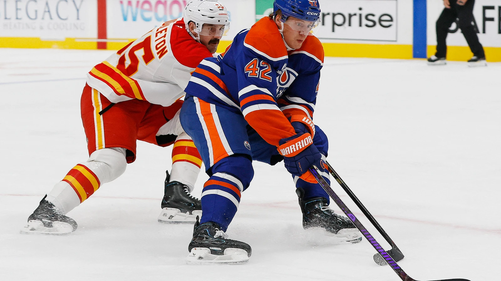 Edmonton Oilers forward Kasperi Kapanen protects the puck from a Calgary Flames defender during their September 26, 2026 preseason game at Rogers Place.