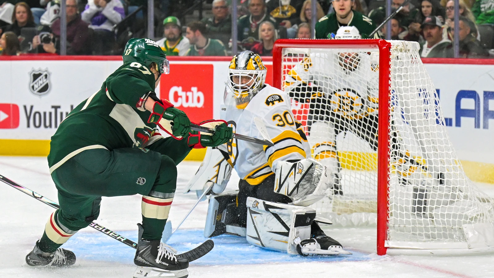 Kirill Kaprizov handles the puck near Boston Bruins goaltender Michael DiPietro during their game in Saint Paul.