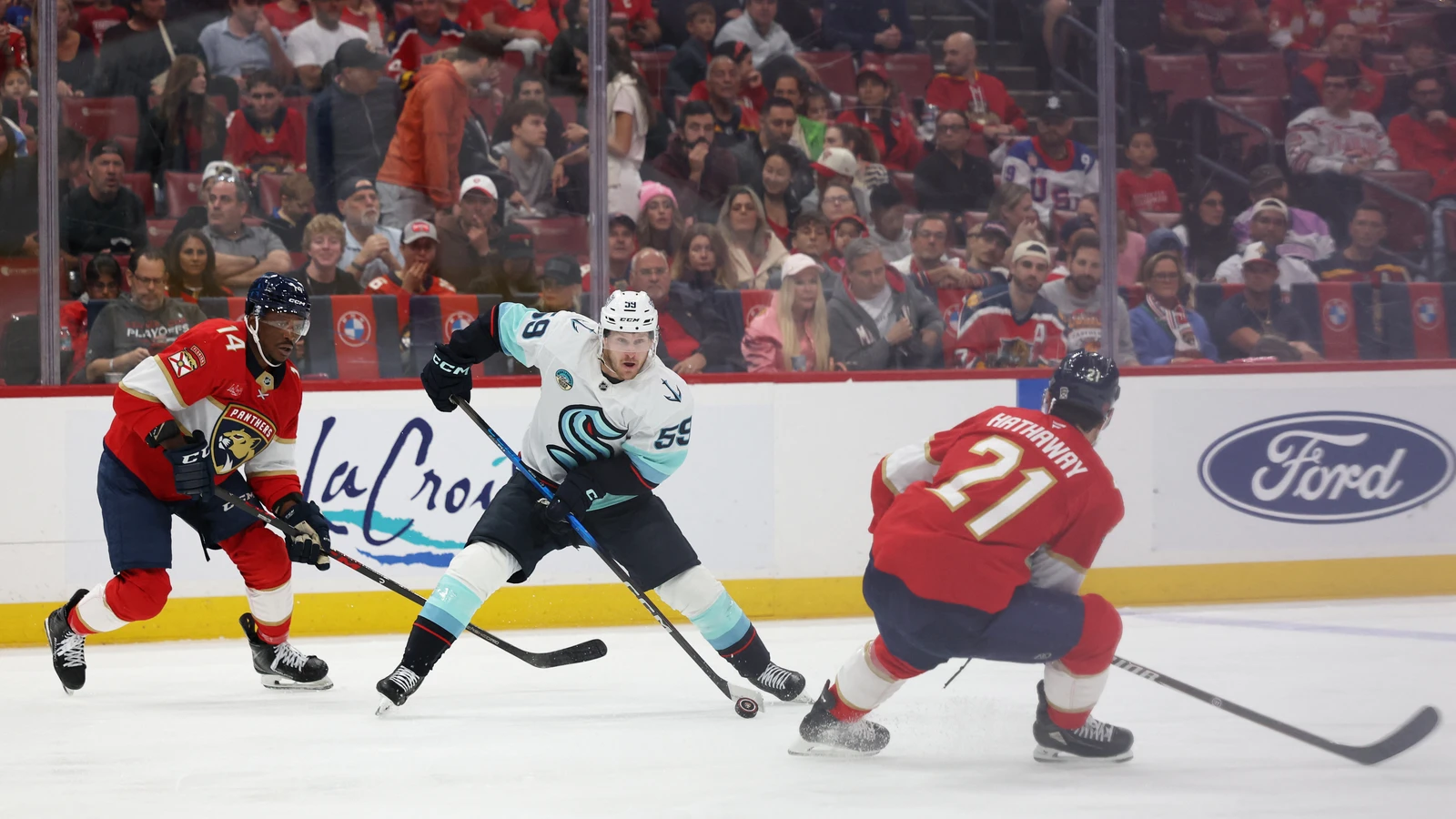 File photo: Seattle Kraken centre Ben Meyers carries the puck between Florida Panthers players at Amerant Bank Arena.