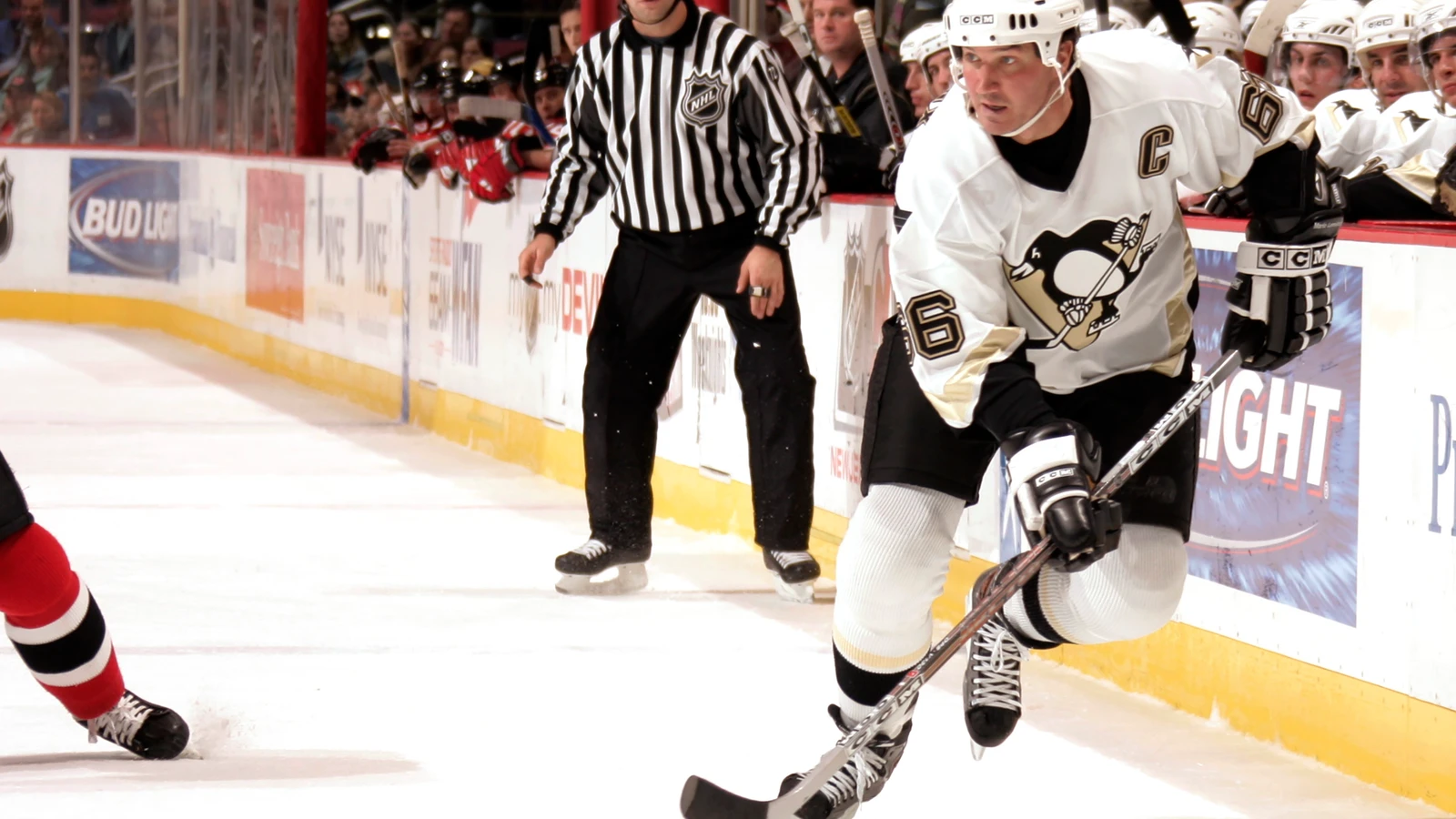 File photo: Mario Lemieux handles the puck in a white Pittsburgh Penguins jersey against the New Jersey Devils.