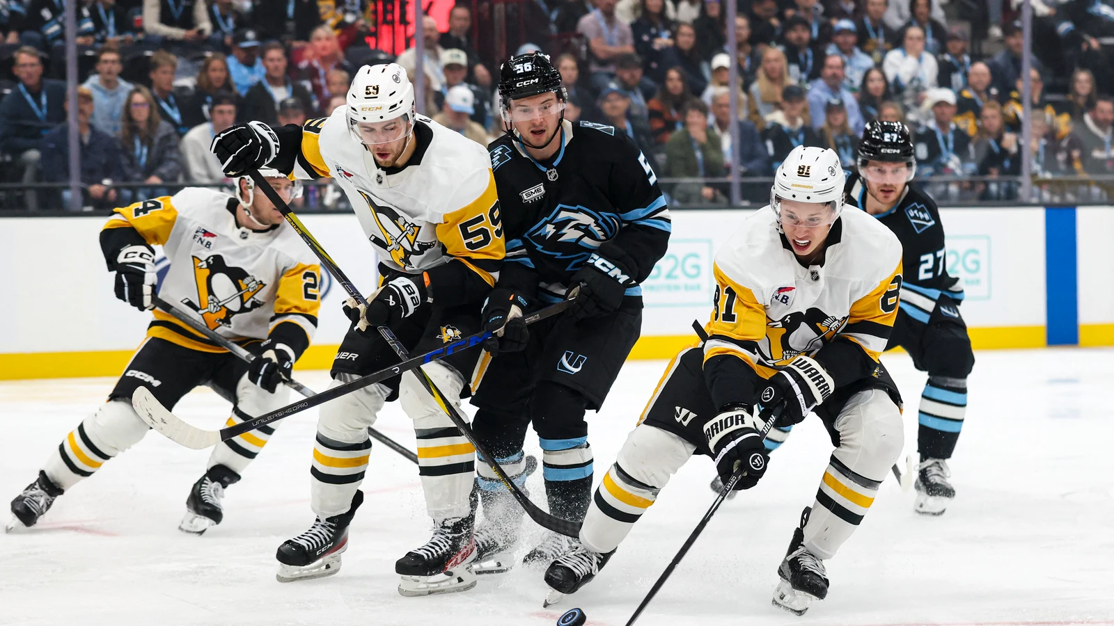 Kailer Yamamoto battles for the puck with Egor Chinakhov and Ben Kindel at Delta Center.