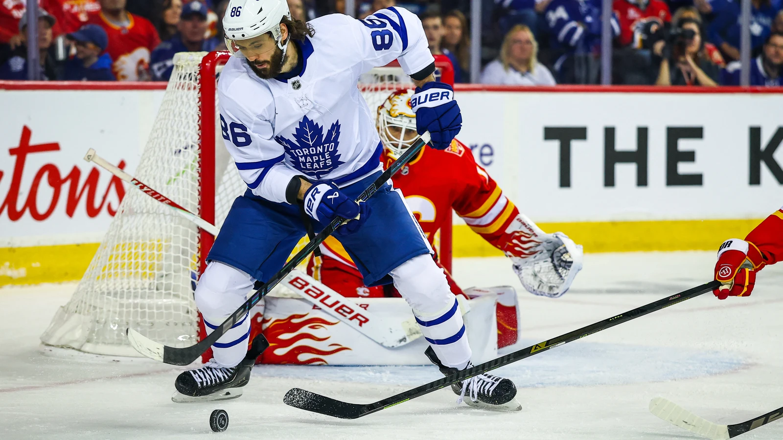 Toronto Maple Leafs winger Kirill Marchenko controls the puck in front of Calgary Flames goaltender Devin Cooley at Scotiabank Saddledome.