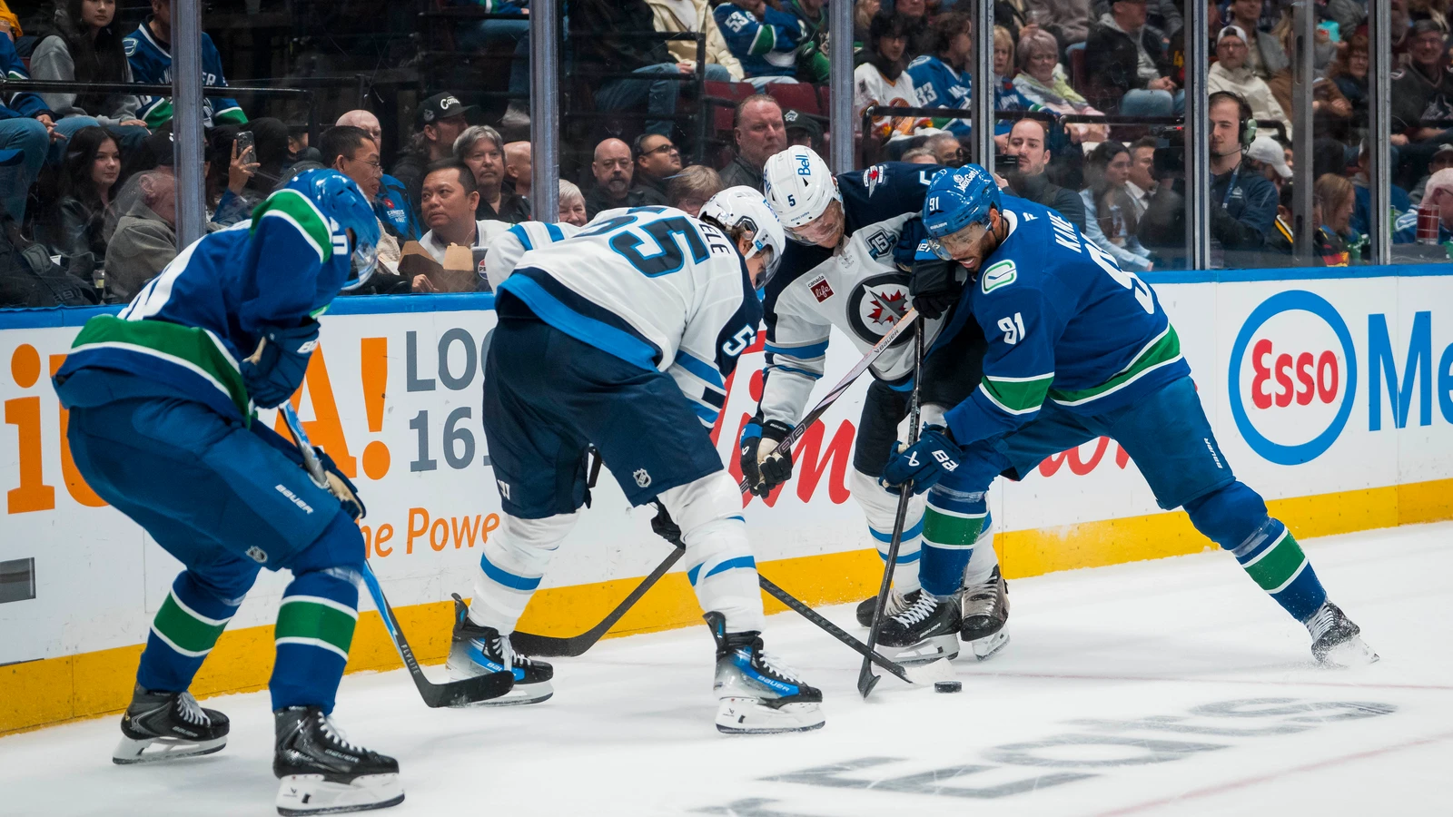 Winnipeg defenseman Luke Schenn battles Vancouver forward Evander Kane as Mark Scheifele joins the play and Elias Pettersson watches at Rogers Arena on November 11, 2025. File photo.
