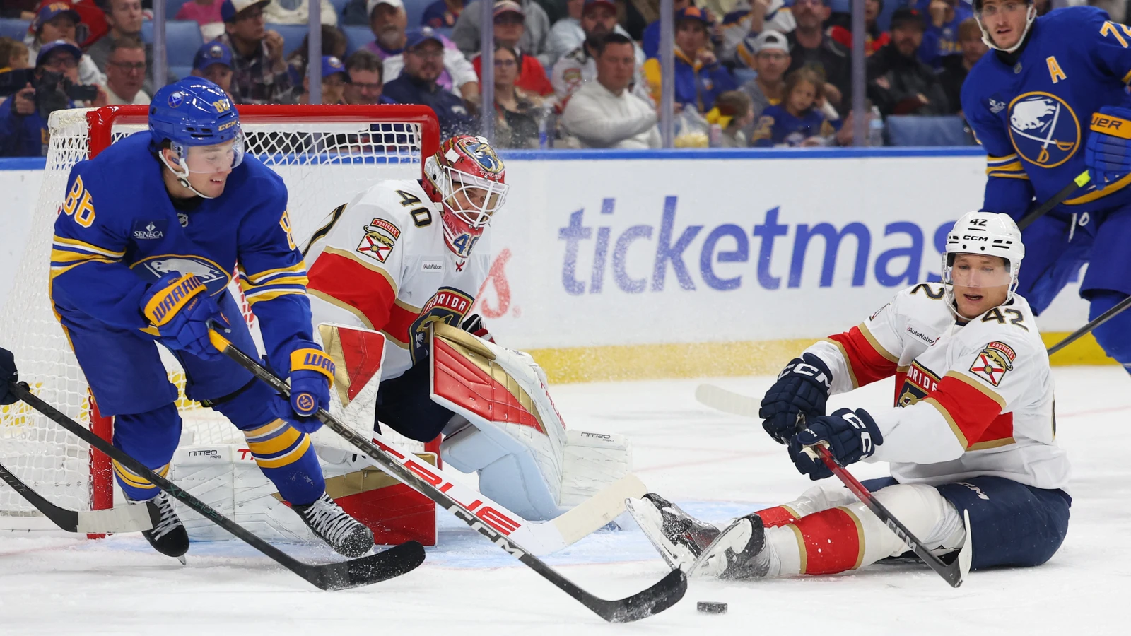 Buffalo Sabres centre Noah Ostlund pursues the puck beside Florida Panthers goaltender Akira Schmid and defenceman Gustav Forsling.