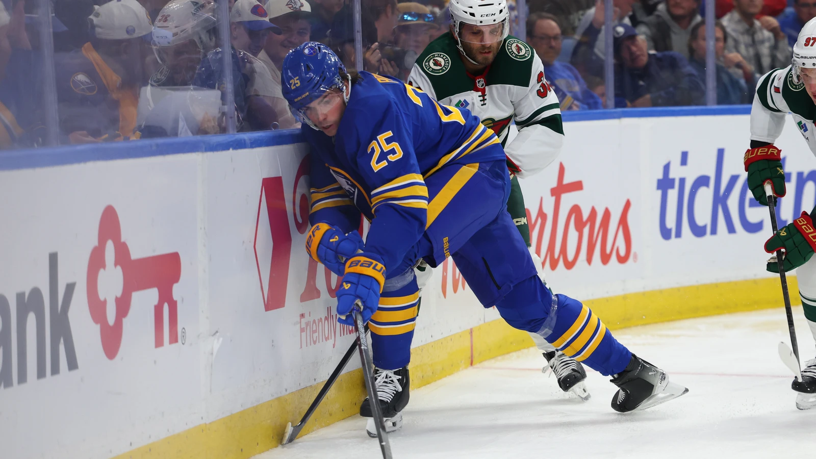 Buffalo Sabres defenceman Owen Power plays the puck along the boards as a Minnesota Wild player defends at KeyBank Center.