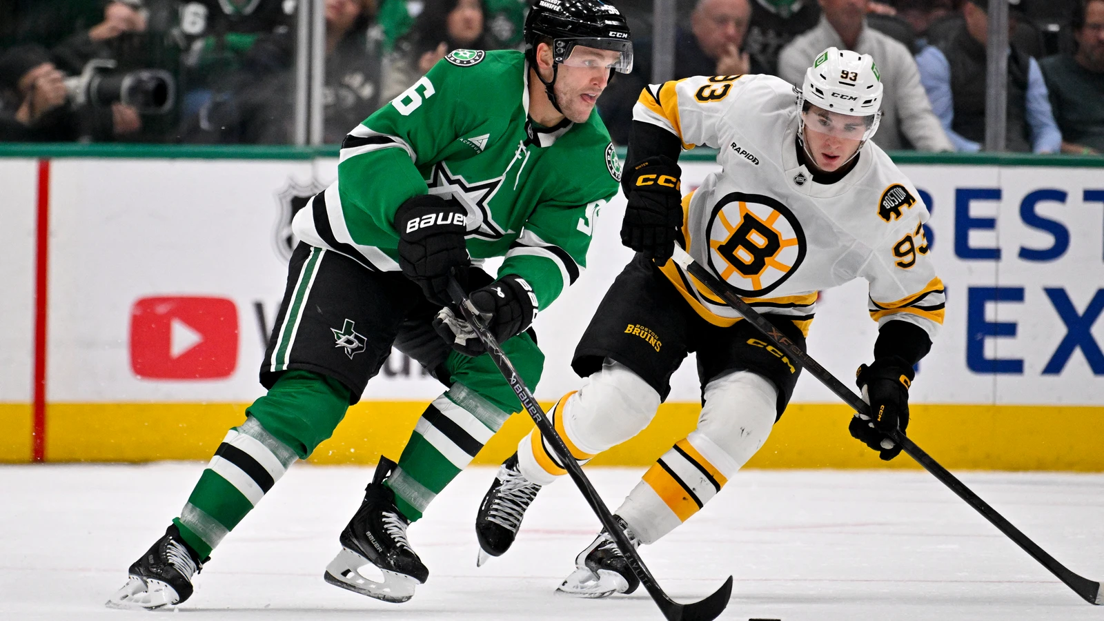 Dallas Stars forward Mikko Rantanen carries the puck past Boston Bruins forward Fraser Minten.