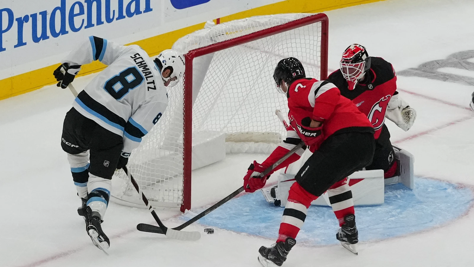Nick Schmaltz controls the puck beside the Devils net as Dougie Hamilton defends at Prudential Center.