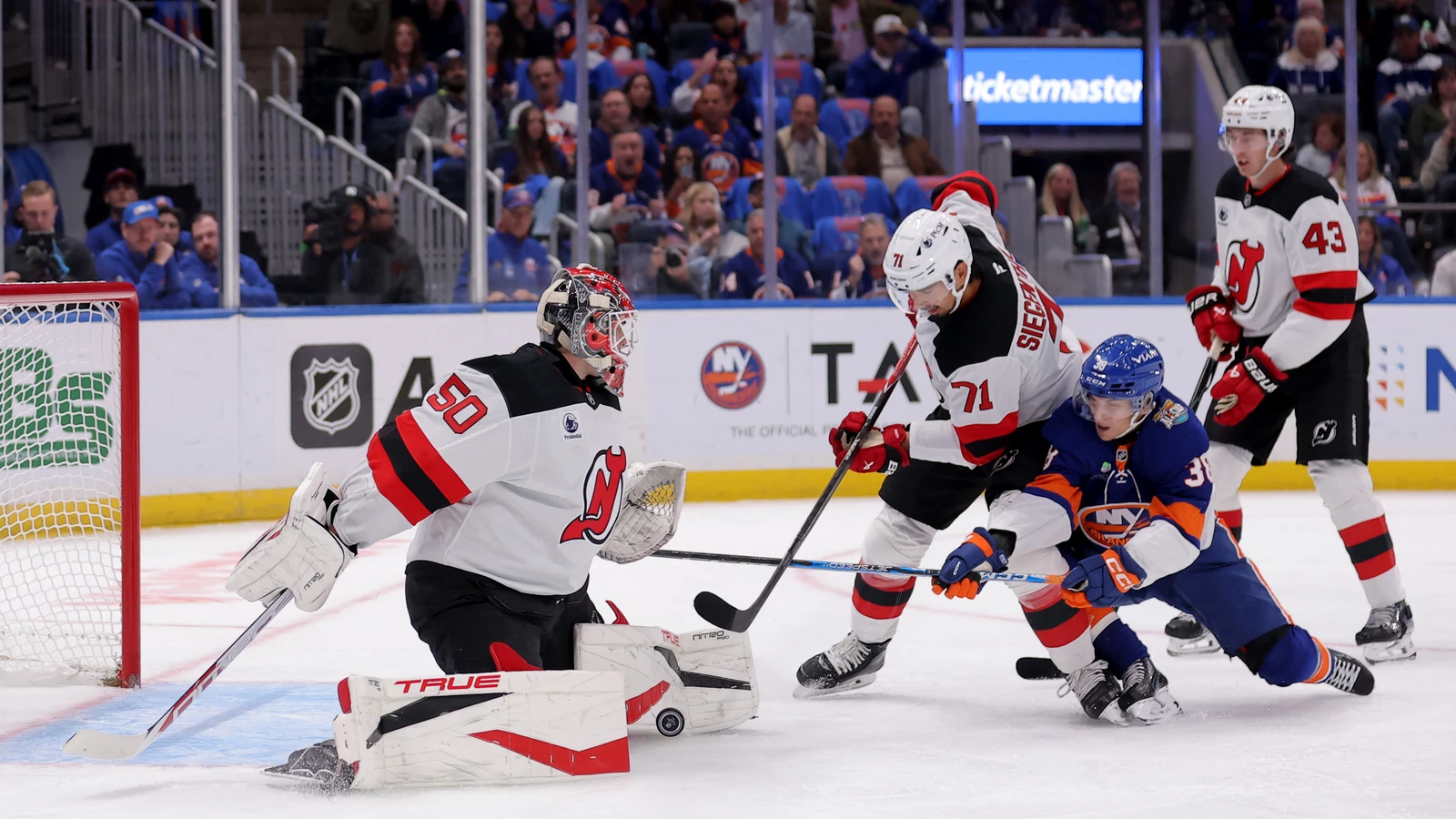 File photo: New Jersey Devils defenceman Jonas Siegenthaler battles for the puck in front of goaltender Nico Daws against the New York Islanders.