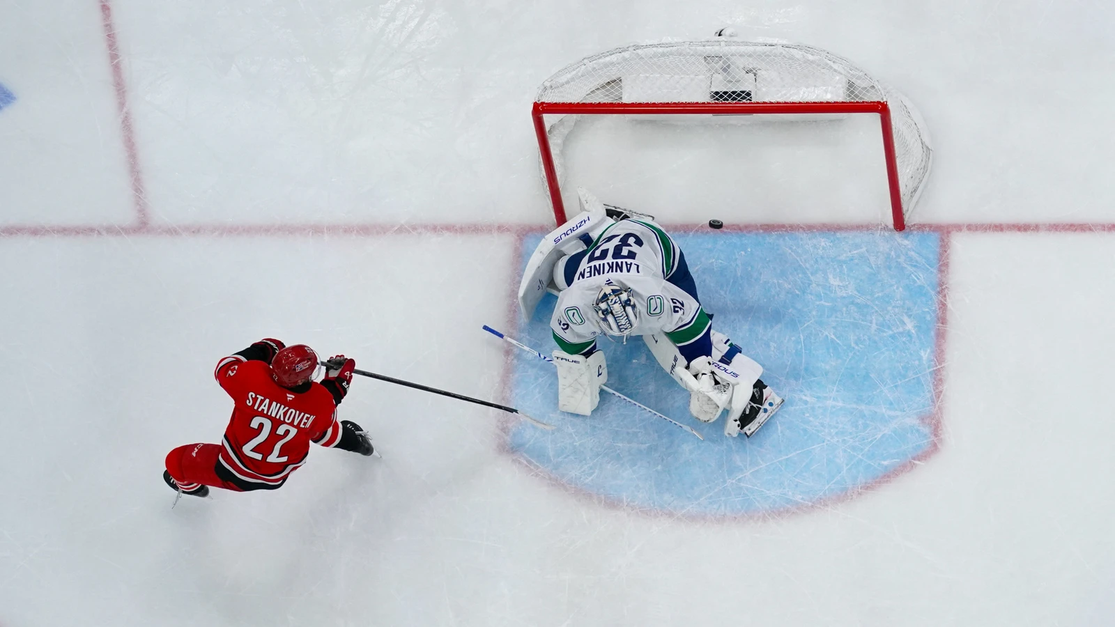 Logan Stankoven scores against Kevin Lankinen during Carolina's game against Vancouver at Lenovo Center.