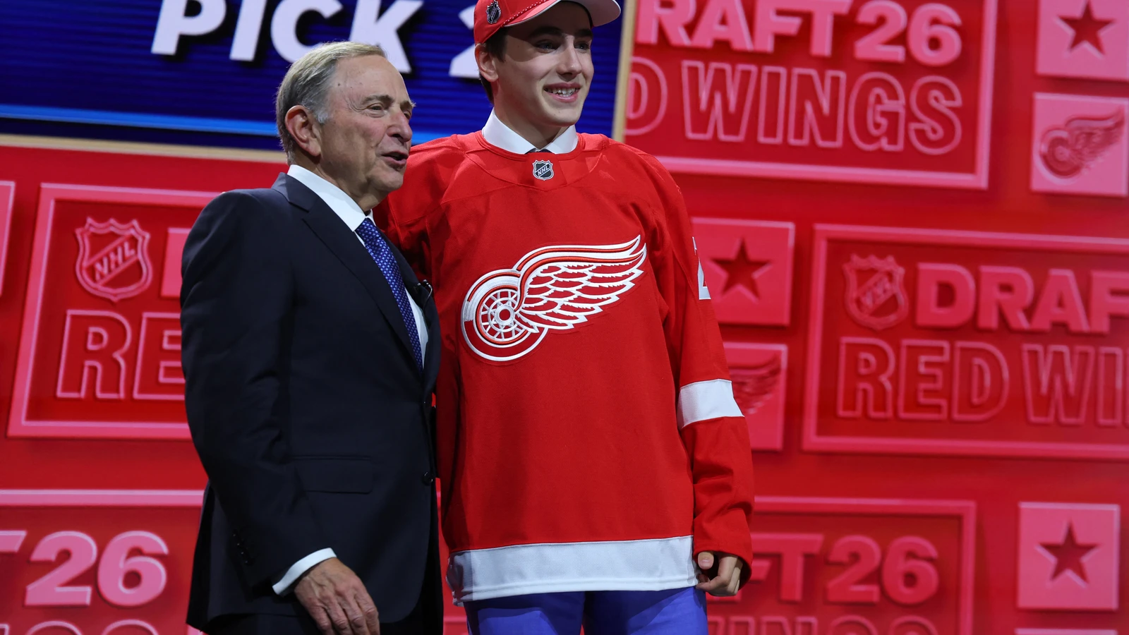 Detroit first-round pick JP Hurlbert stands beside NHL commissioner Gary Bettman after being selected 23rd overall at the NHL Draft on June 26, 2026. File photo.
