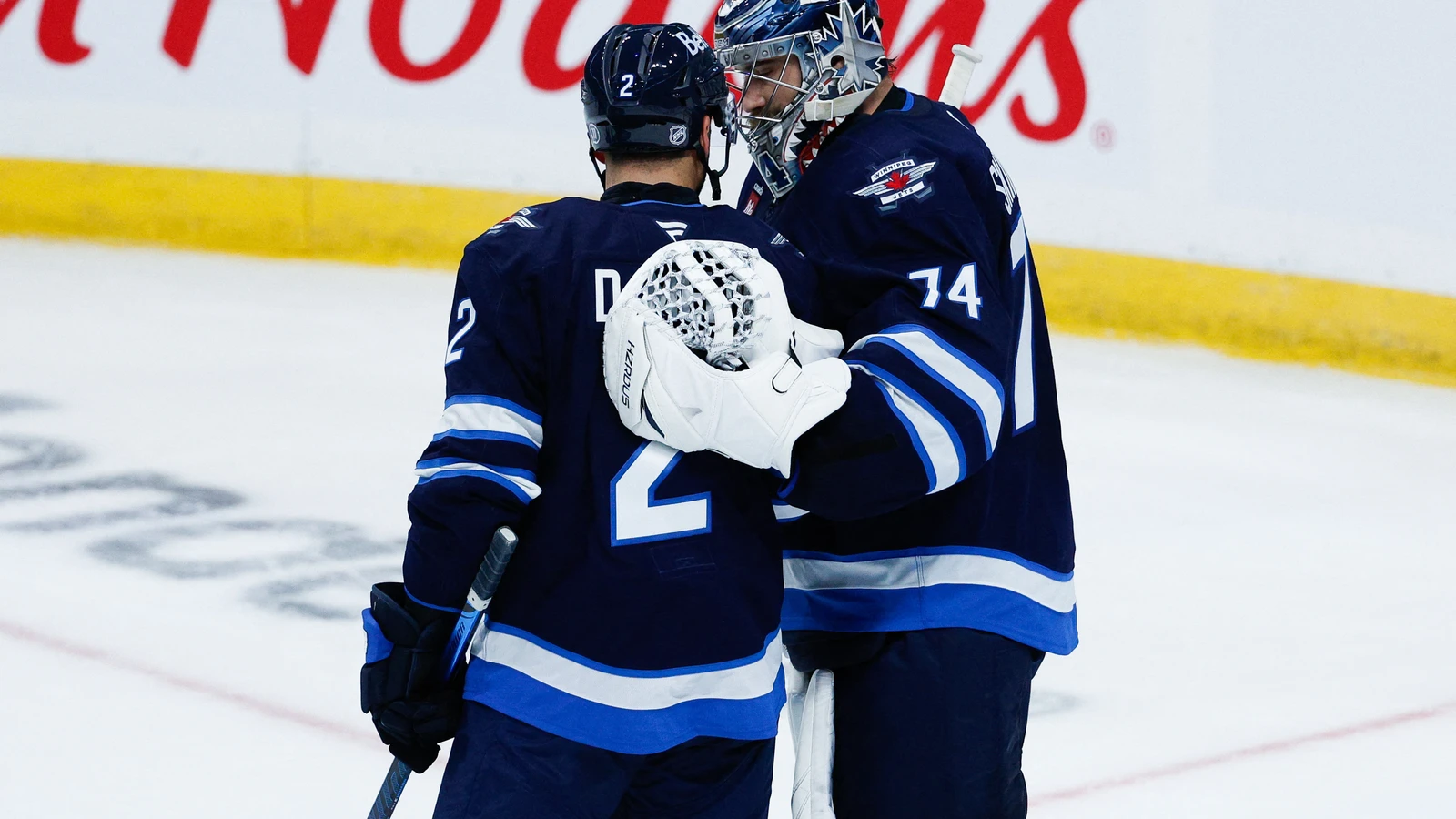 Winnipeg Jets goalie Stuart Skinner (74) is congratulated by teammate Dylan DeMelo (2) after beating Colorado at Canada Life Centre on Sept. 21, 2026.