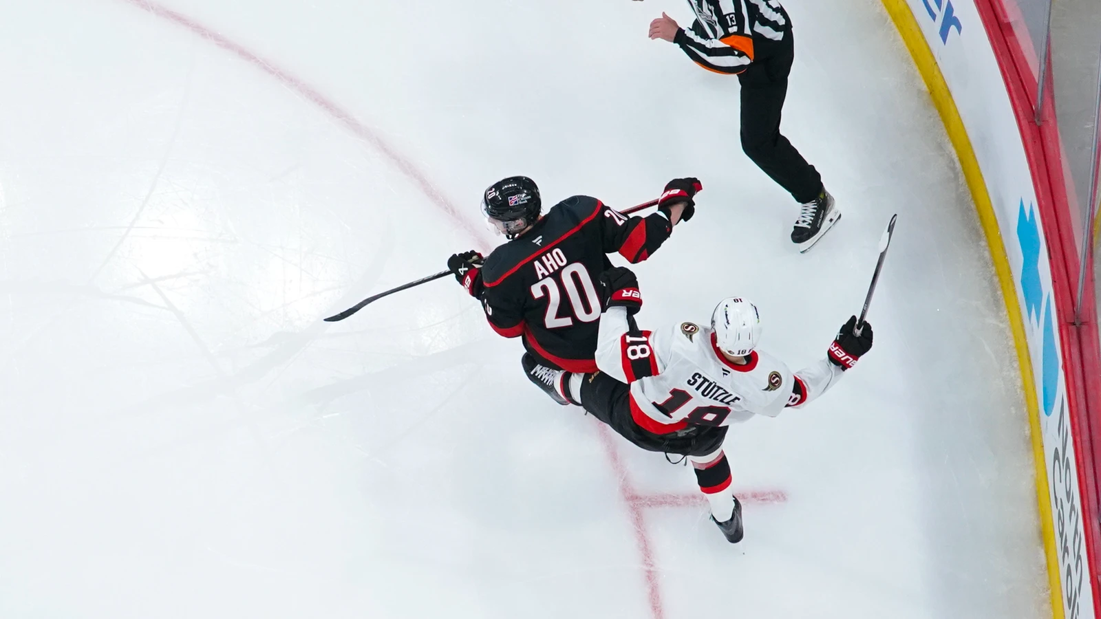 Tim Stützle is checked by Sebastian Aho during Ottawa's playoff game at Carolina on April 20, 2026. File photo.