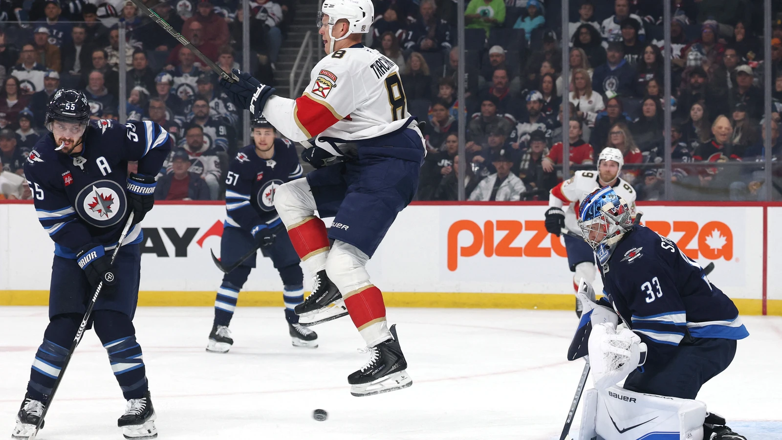 Brady Tkachuk jumps over a shot in front of Winnipeg Jets goaltender Clay Stevenson at Canada Life Centre.
