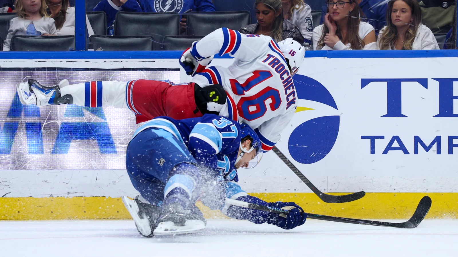 File photo: Vincent Trocheck, wearing a New York Rangers jersey, collides with Tampa Bay Lightning forward Yanni Gourde.