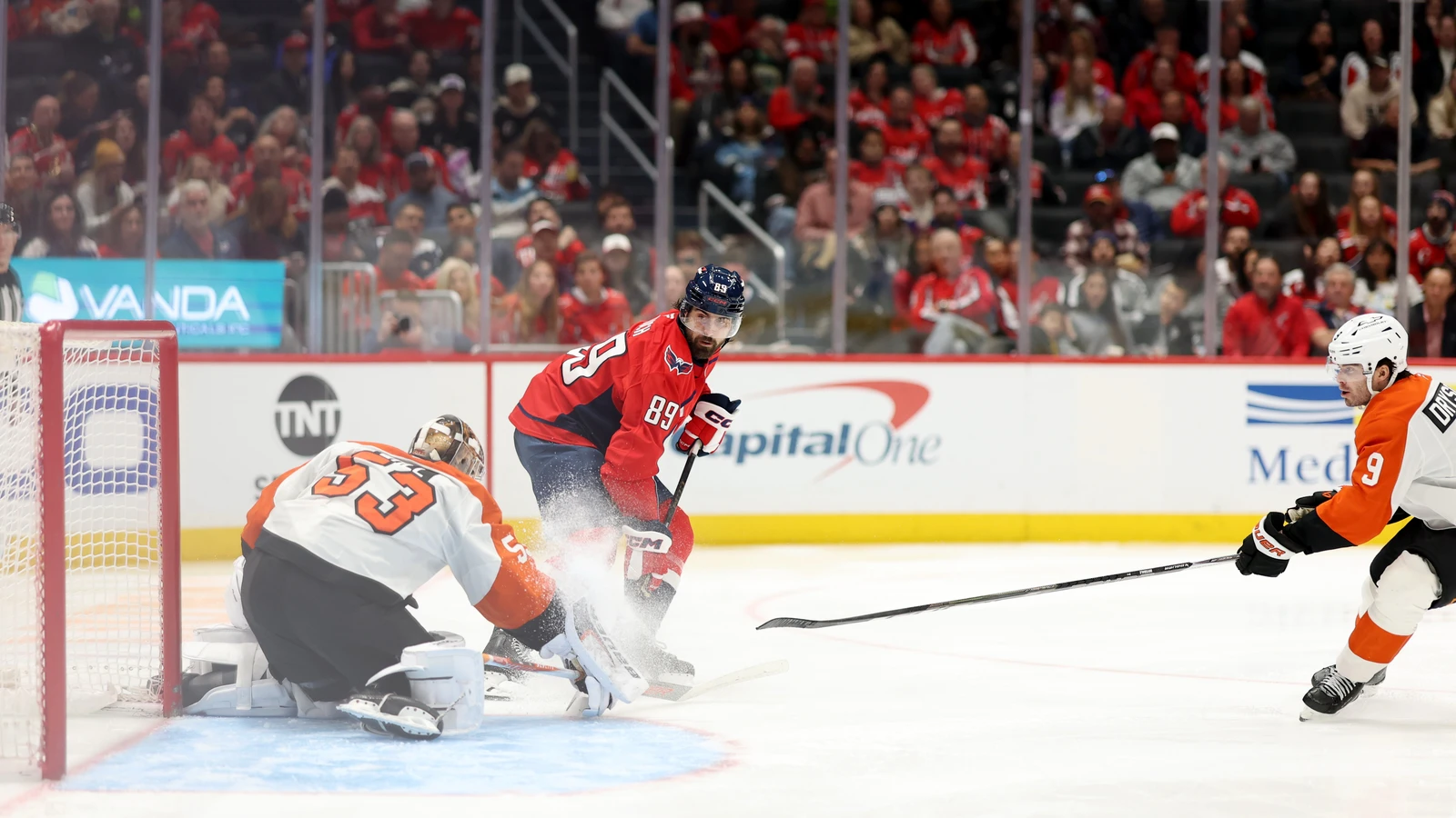 Washington Capitals forward Alex Tuch plays the puck in front of Philadelphia Flyers goaltender Joseph Woll at Capital One Arena.