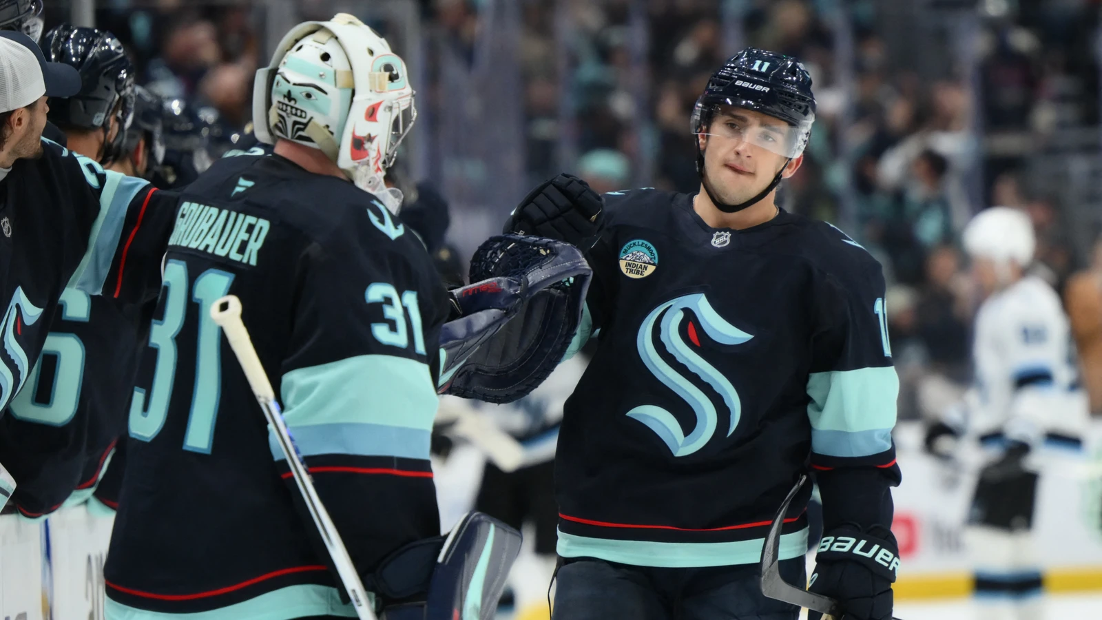 File photo: Seattle Kraken forward Mackie Samoskevich celebrates with goaltender Philipp Grubauer at Climate Pledge Arena.